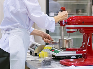 Culinary student working with hot pad 