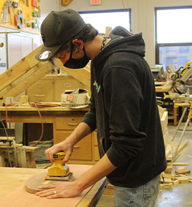 Student making wooden football